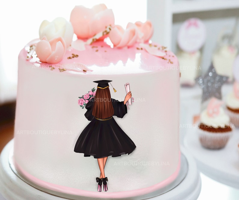 May include: A pink and white cake decorated with pink sugar flowers and a fondant topper of a woman in a black graduation gown holding a diploma. The cake is on a white cake stand.