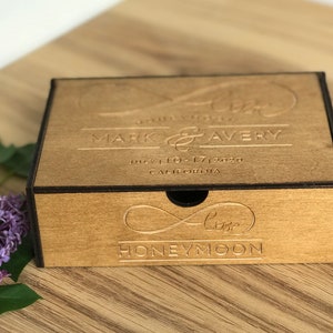 Peut inclure: Une boîte en bois avec un couvercle coulissant, gravée du texte "Forever Love Mark & Avery July 10-17, 2020 California" sur le dessus et "Forever Love Honeymoon" sur le devant.