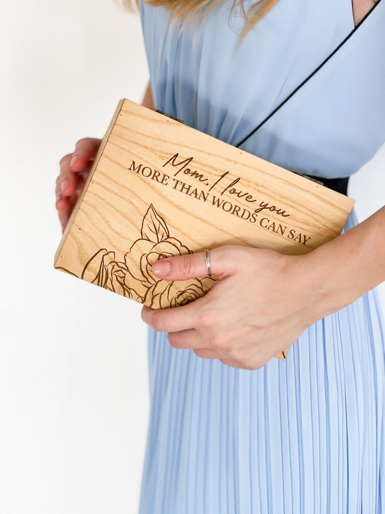 Puede incluir: Una caja de madera con un dise&ntilde;o floral y el texto "Mam&aacute;, te quiero m&aacute;s de lo que las palabras pueden decir".