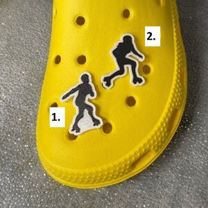 May include: Yellow shoe with two black and white skater silhouette patches. The patches are numbered 1 and 2.