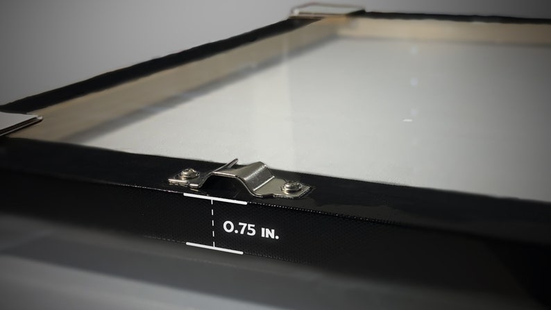 May include: Close-up of a black canvas frame with a metal hanging bracket. The frame is 0.75 inches thick.