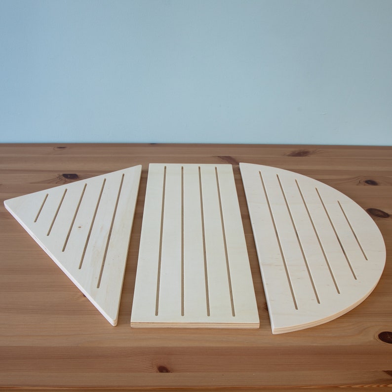 Pu&ograve; includere: Tre pezzi di legno, un triangolo, un rettangolo e un semicerchio, ognuno con una serie di linee parallele tagliate nella superficie.