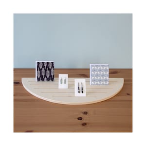 Expositor de pendientes y tarjetas con ranuras para mostradores, utilizado en comercios minoristas, ferias de artesanía y mercados.