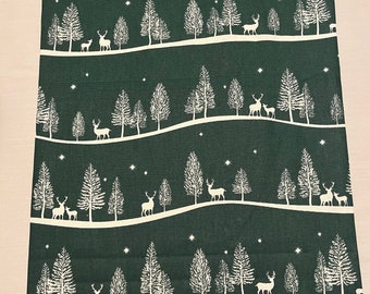 May include: A green fabric with a white repeating pattern of stylized trees and deer. The fabric has a subtle texture and a slightly faded look.