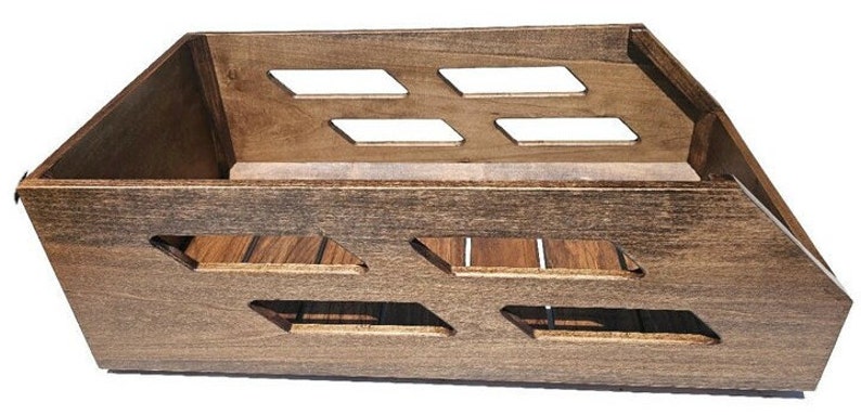May include: A dark brown wooden storage crate with a slatted bottom and open sides. The crate has a unique design with cutouts on the front and sides.
