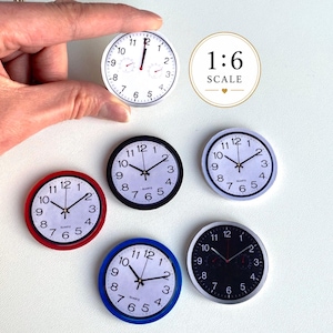 May include: A collection of six miniature round wall clocks in 1:6 scale, featuring various colored frames including red, blue, black, and white. Each clock has a white or black face with black numerals, hour, minute, and second hands.