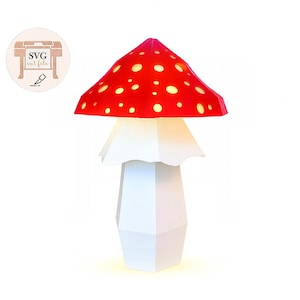May include: A whimsical mushroom-shaped lamp with a red cap dotted with yellow spots. The lamp has a white stem and a white, ruffled base. The lamp is illuminated, creating a warm glow. The image also includes the text "SVG cut file".