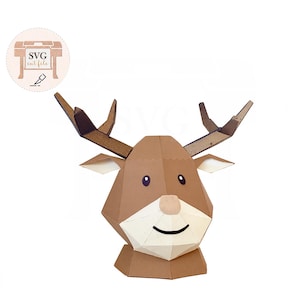 May include: A geometric papercraft reindeer head with brown and cream-colored sections. The reindeer has large antlers, a smiling mouth, and a small nose. The image includes the text "SVG cut file" in a circular logo.