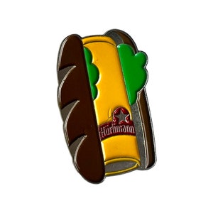 以下が含まれることがあります： ホルメルの文字と赤い星が書かれた黄色のマスタードボトルと、緑のピクルスを添えたホットドッグの茶色と黄色のエナメルピン