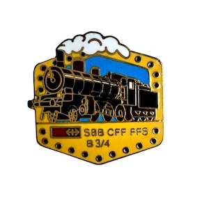 May include: A metal enamel pin featuring a black steam locomotive against a blue sky with white smoke. The yellow border has small circular cutouts. The text SBB CFF FFS B 3/4 is printed in black on the lower yellow section with a red rectangle.