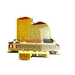 May include: A gold-toned metal pin featuring a red and yellow train carriage with the text SSG and WR 33501. Above the train, there are two yellow blocks of Swiss cheese with holes, one rectangular and one wedge-shaped, set against a gold background.