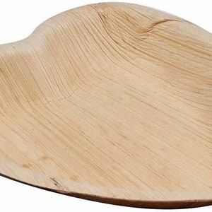 May include: A heart-shaped, light brown, disposable plate made from palm leaves. The plate is slightly curved and has a smooth surface.