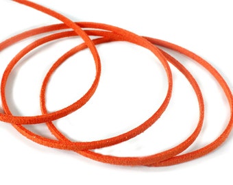 May include: Close-up of a vibrant orange leather cord, coiled into three loops, with a single strand extending upwards. The cord is set against a clean white background, highlighting its color and texture. Ideal for jewelry making or crafting.
