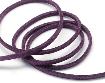 May include: Close-up of a coiled, dark purple suede cord against a white background. The cord appears to be approximately 3mm in diameter. The texture of the suede is visible, with a slightly rough, matte finish. This cord is suitable for jewelry making and crafts.