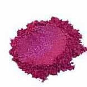 May include: A close-up of a pile of deep pink mica powder. The powder has a shimmery, iridescent finish.