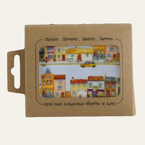 May include: A brown cardboard package with a microfiber lens cloth inside. The cloth features a colorful illustration of a street scene with buildings and a yellow car. Text on the package reads "Glasses . Screens . Tablets . Camera."