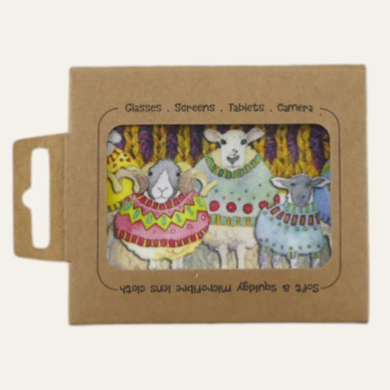May include: A brown cardboard package with a rectangular window displaying a microfiber lens cloth. The cloth features a colorful illustration of three sheep wearing sweaters. Text on the package reads "Glasses. Screens. Tablets. Camera" and "Soft & squidgy microfiber lens cloth."