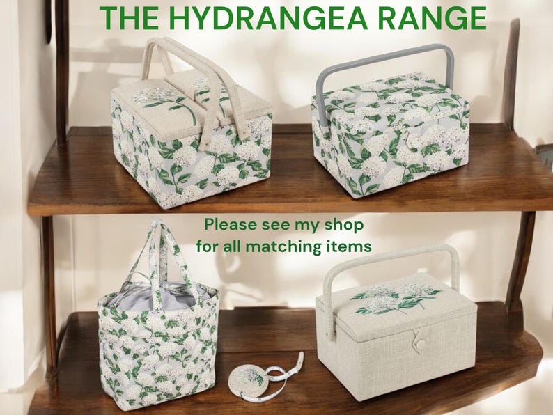 May include: Four fabric storage boxes with a floral pattern. The boxes are arranged on a wooden shelf. The text "The Hydrangea Range" is at the top of the image. The text "Please see my shop for all matching items" is in the middle of the image.