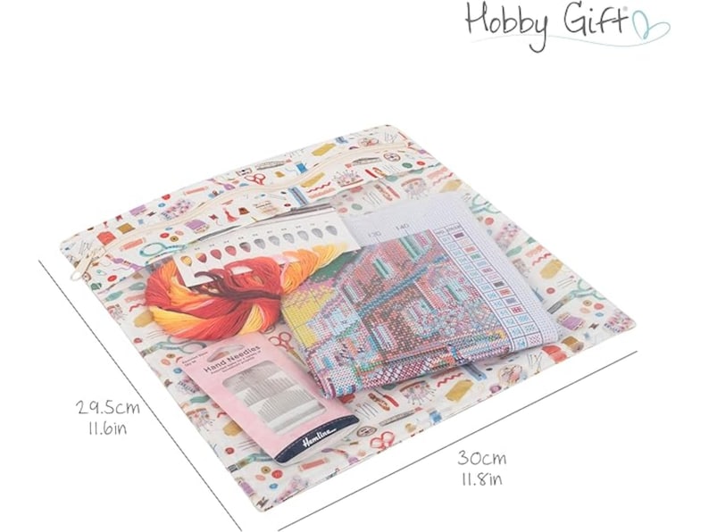 May include: A white fabric bag with a colorful pattern of sewing supplies, including needles, thread, scissors, and buttons. The bag contains a cross-stitch kit with a printed design and a pack of needles. The bag measures 11.8 inches by 11.6 inches.