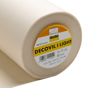 May include: A roll of beige Decovil I Light fabric, 90 cm wide and 15 m long. The label includes the brand name Vlieseline and the fabric composition: 42% PES, 35% CV, and 23% PA. The fabric is suitable for ironing.