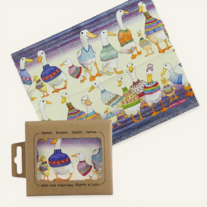 May include: A microfiber cleaning cloth featuring a whimsical illustration of ducks wearing sweaters. The cloth is light yellow with a blue border and comes with a cardboard package. The package has the text "Glasses, Screens, Tablets, Camera".