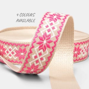 Può includere: Nastro beige con un motivo floreale rosa e bianco. Il nastro è arrotolato e piegato, mostrando il motivo e il testo "4 COLORI DISPONIBILI". Questo nastro è adatto per lavori di artigianato, cucito o confezioni regalo.