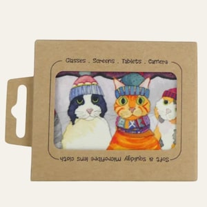 May include: A microfiber lens cloth featuring a colorful illustration of three cats wearing winter hats and scarves. The cloth is packaged in a brown cardboard box with text that reads "Glasses . Screens . Tablets . Camera."
