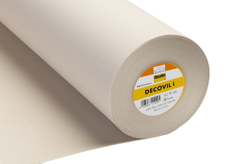 May include: A roll of white Decovil I interfacing fabric for sewing projects. The label reads "Decovil I" and lists the fabric composition as 42% PES, 35% CV, 23% PA. The roll is 90 cm wide and 15 meters long.