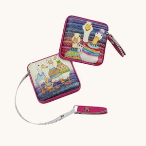 May include: Two square tape measures with a pink border and a goose family design. One tape measure is extended, showing the white measuring tape. The geese are wearing colourful sweaters and dresses.