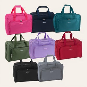 Könnte beinhalten: Eine Sammlung von acht rechteckigen Reisetaschen in verschiedenen Unifarben, darunter Pink, Marineblau, Petrol, Olivgrün, Lavendel, Rot, Schwarz und Grau. Jede Tasche verfügt über zwei Tragegriffe, ein Hauptfach mit Reißverschluss und eine Fronttasche.