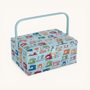 May include: A rectangular sewing box with a pale blue handle and a matching patterned lid. The lid features a repeating pattern of colourful sewing machines on a light blue background. The box has a clasp closure.