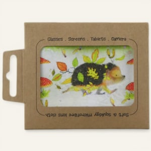 May include: A microfiber lens cloth featuring a whimsical hedgehog design with autumn leaves and mushrooms. The cloth is packaged in a brown cardboard sleeve with the text "Glasses. Screens. Tablets. Camera" and "Soft & squidgy microfiber lens cloth."