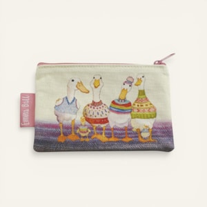 May include: A rectangular zipped pouch with a duck family illustration. The ducks wear colourful sweaters and stand on a purple and grey patterned base. The pouch has a pink zip and a pink tag that reads "Emma Ball".