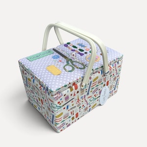 May include: A rectangular sewing basket with a white plastic handle and a light purple polka dot lid. The lid features the name Charlotte and a graphic of scissors. The sides are covered in a colourful pattern of sewing tools and notions.