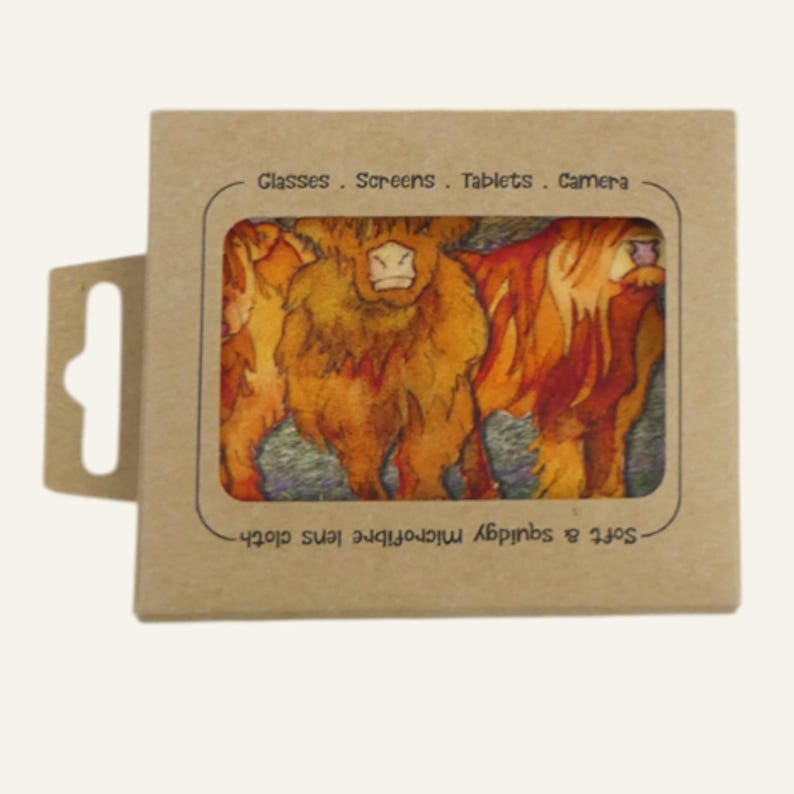 May include: A microfiber lens cloth featuring a watercolor painting of Highland cows in shades of orange, brown, and yellow. The cloth is packaged in a brown cardboard box with the text "Glasses . Screens . Tablets . Camera".