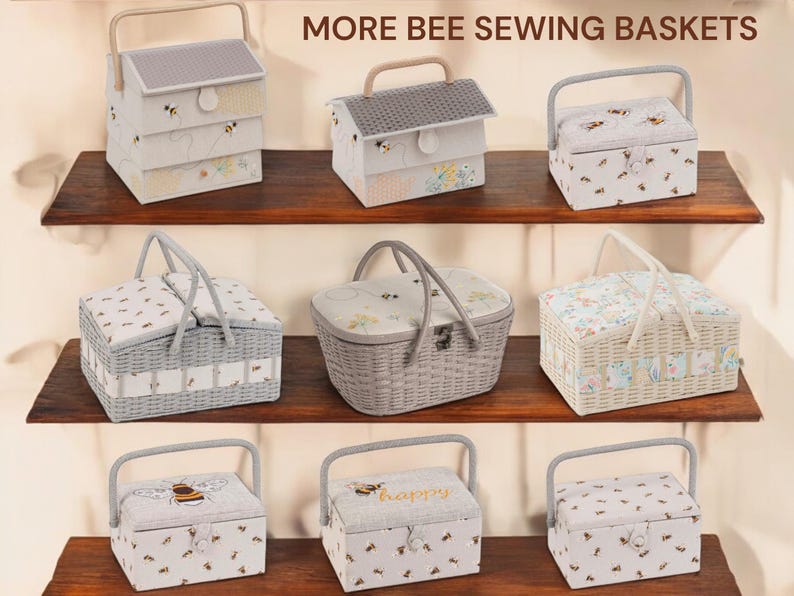 May include: A collection of bee-themed sewing baskets in various shapes and sizes. The baskets feature light colors, floral patterns, and bee motifs. Some have handles, while others have a house-like design. The text "MORE BEE SEWING BASKETS" is visible.