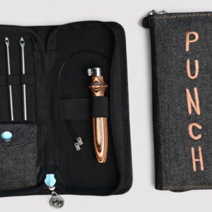 May include: A black denim punch needle tool kit with a zippered case. The kit includes various needles, a wooden handle punch needle, and a separate case with the word "PUNCH" embroidered in peach. The kit is designed for punch needle embroidery.