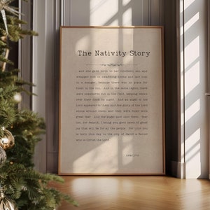 May include: A framed print with the text "The Nativity Story" and a passage about the birth of Jesus. The print is hanging on a wall next to a decorated Christmas tree.