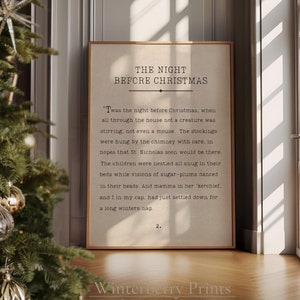 Peut inclure: Une impression encadrée du poème "The Night Before Christmas" est posée sur un sol en bois, à côté d'un sapin de Noël décoré. L'impression a un fond beige avec du texte noir. L'arbre est orné de décorations dorées et argentées.