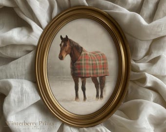 May include: An oval framed print of a horse standing in a snowy field. The horse is brown with a red and green plaid blanket. The frame is gold and the artwork is labeled "Winterberry Prints Printable Artwork".