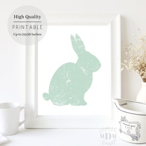 Puede incluir: Una descarga digital imprimible con una silueta de conejo verde claro sobre un fondo blanco. La imagen es de alta calidad y se puede imprimir hasta 61x91 cm.