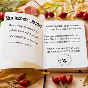 May include: Open book with white pages and black text. The text reads "Winterberry Prints" and includes information about digitally remastered images. The book is lying open on a wooden surface with autumn leaves and red berries.