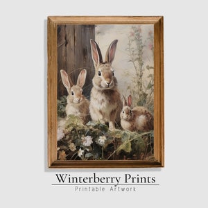 May include: A framed painting of three brown rabbits in a field of flowers. The rabbits are looking at the viewer. The painting is in a gold frame.