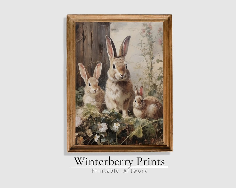 May include: A framed painting of three brown rabbits in a field of flowers. The rabbits are looking at the viewer. The painting is in a gold frame.