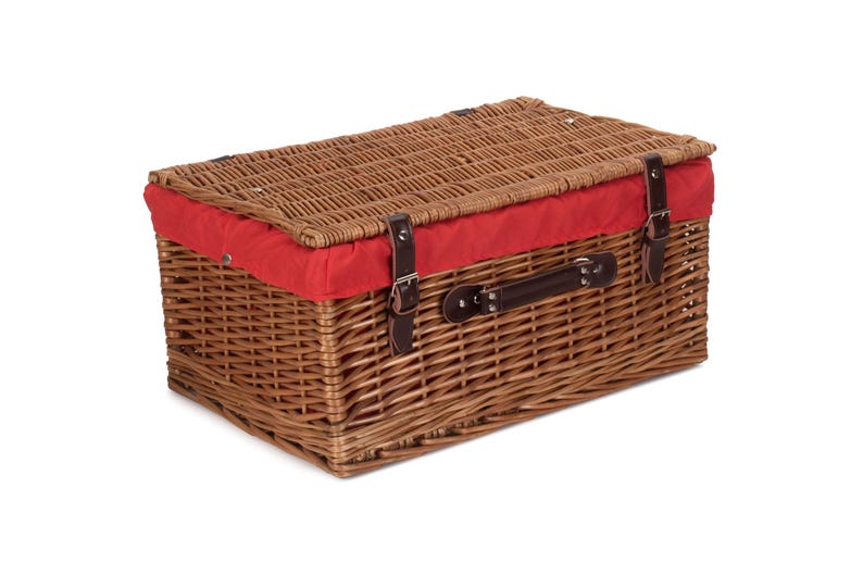 May include: A brown wicker picnic basket with a red fabric lining and a leather handle. The basket has two leather buckles on the front.