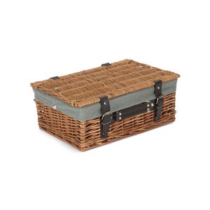 May include: A woven wicker picnic basket with a light blue canvas lid and brown leather straps and buckles.