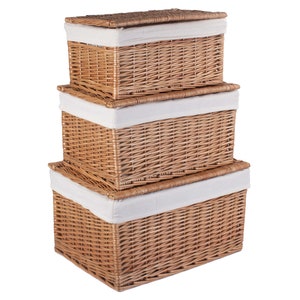 May include: Three wicker storage baskets with white fabric lids stacked on top of each other. The baskets are made of natural woven wicker and have a rectangular shape.
