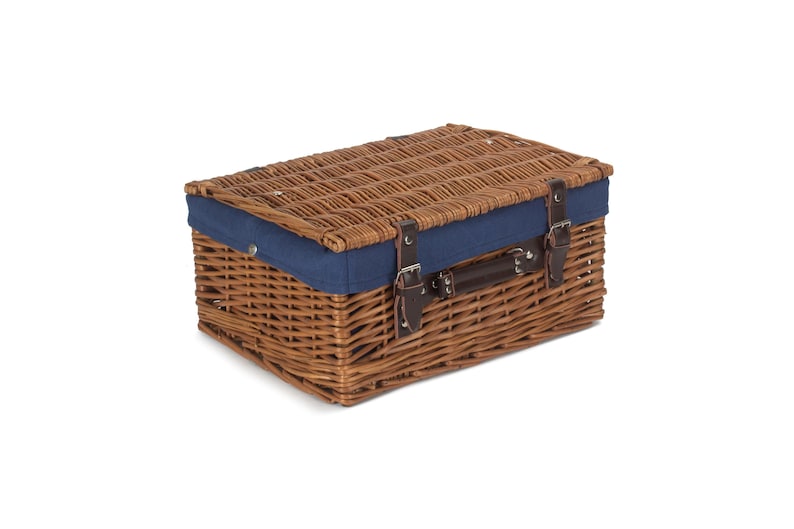May include: A brown wicker picnic basket with a blue fabric lining and leather straps. The basket has a hinged lid and a carrying handle.