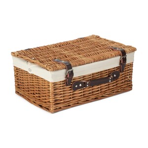 May include: A brown wicker basket with a white fabric lining and a brown leather handle. The basket has two brown leather straps with metal buckles.
