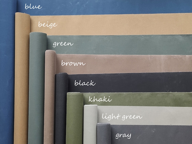 May include: A collection of fabric rolls in various colors, including blue, beige, green, brown, black, khaki, light green, and gray. The fabric rolls are arranged in a vertical stack, with the blue roll at the top and the gray roll at the bottom.